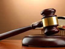 wooden gavel on wooden table, on brown background