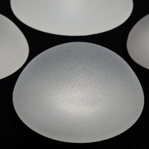silicone breast implants with micro textured surface isolated on black background