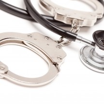 Stethoscope and Handcuffs Isolated on a White Background.