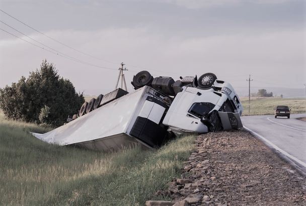 A white semi truck overturned off the highway